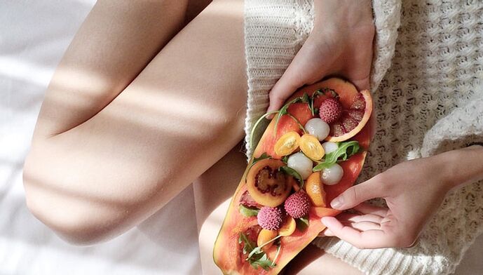 Neska papaia eta beste fruitu batzuekin